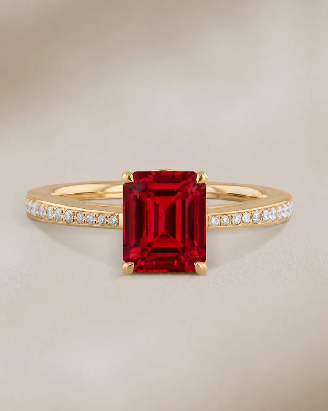 Emerald-cut ruby in yellow gold with diamond pavé band