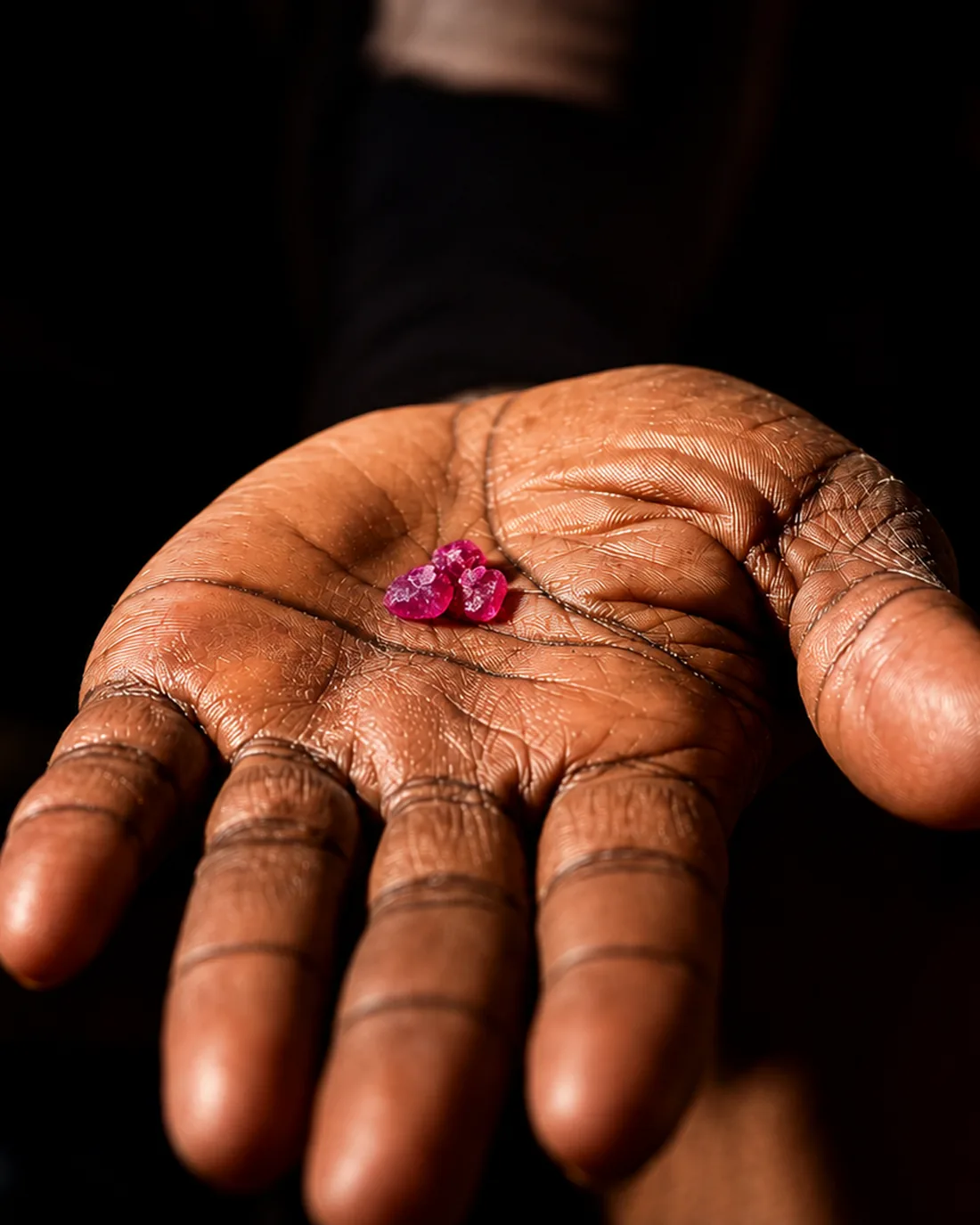 Rough rubies held in an open palm at Montepuez